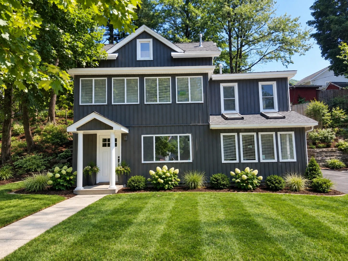 Renovated Russell Avenue house with gray vertical siding, white trim, a covered front entry, and a lawn