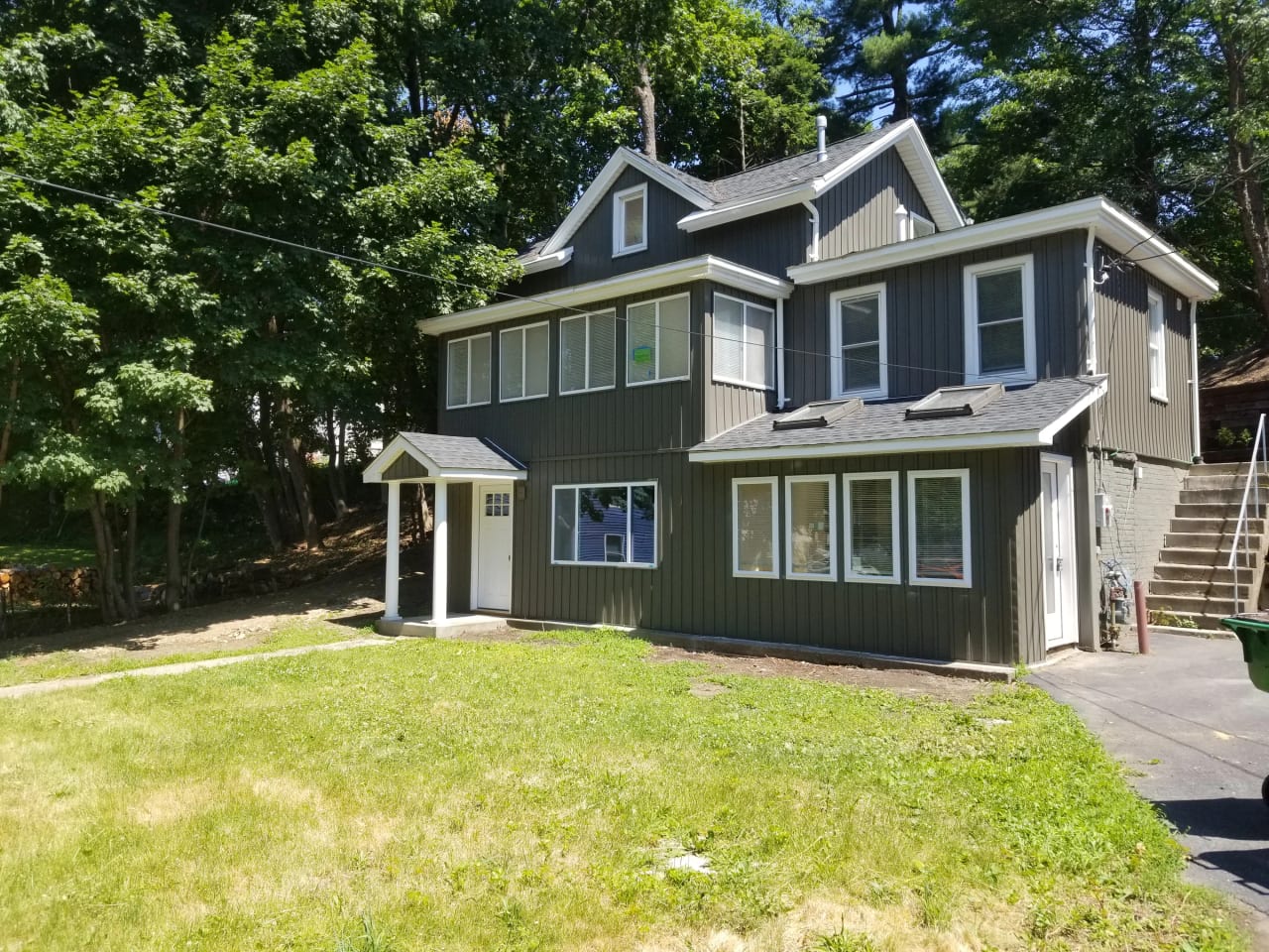 Renovated Russell Avenue house with gray vertical siding and a covered front entry