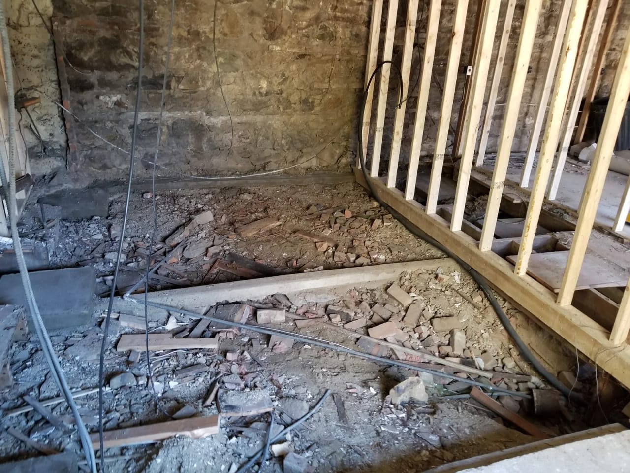 Opened first floor beside the stone foundation wall and new wall framing