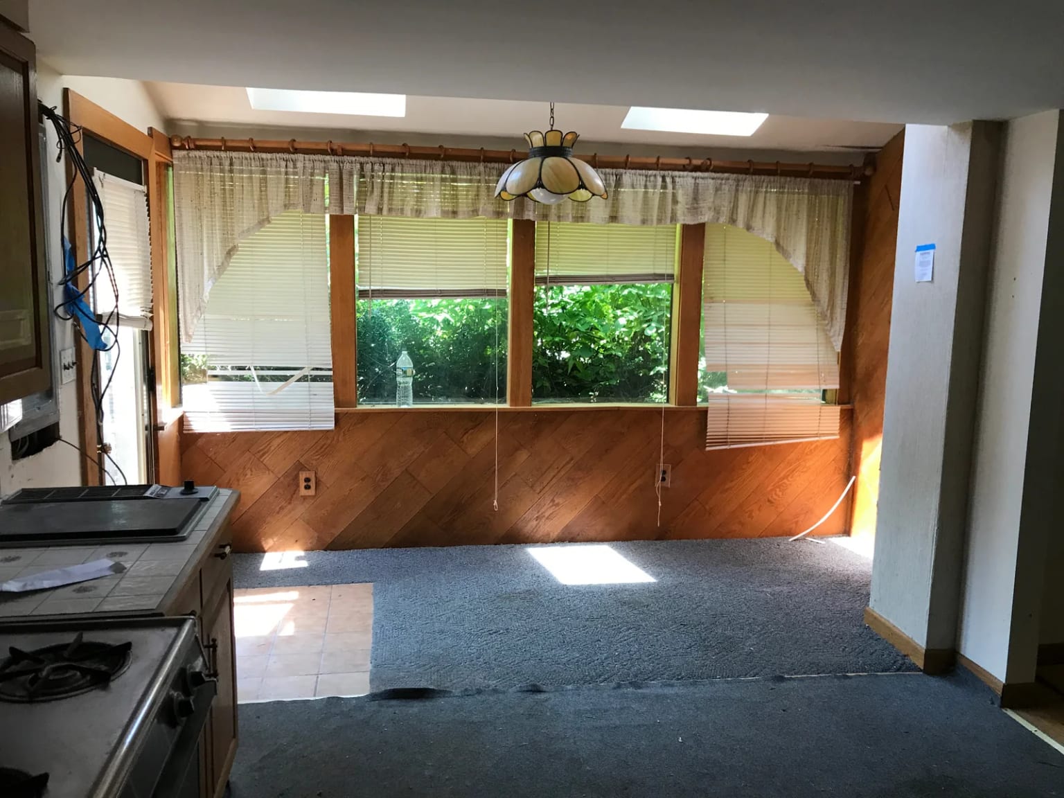 Original interior beside the front windows with wood paneling and carpeting
