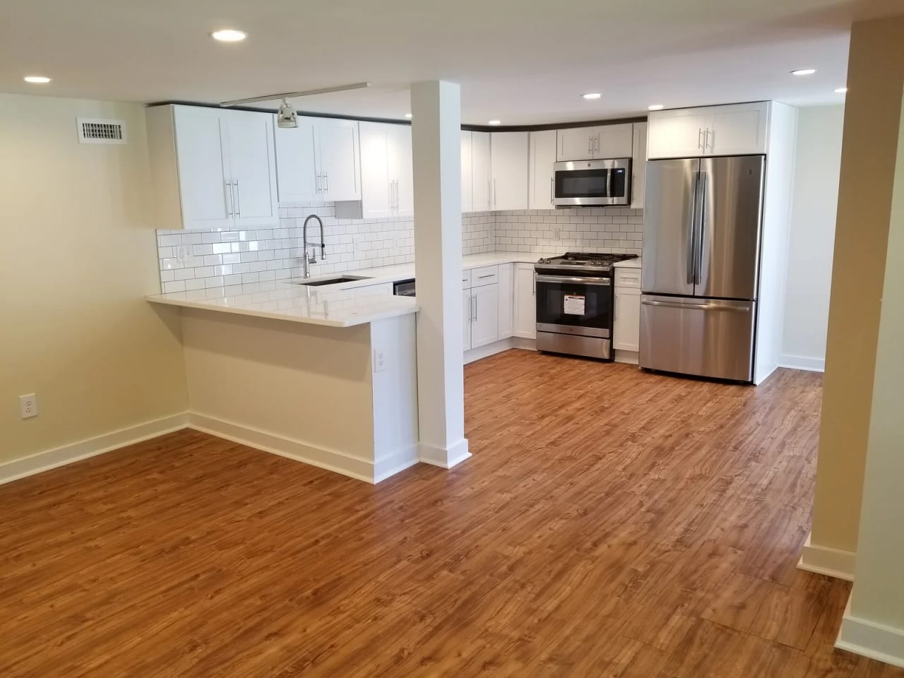 Renovated kitchen opening toward the adjoining wood-floored living space