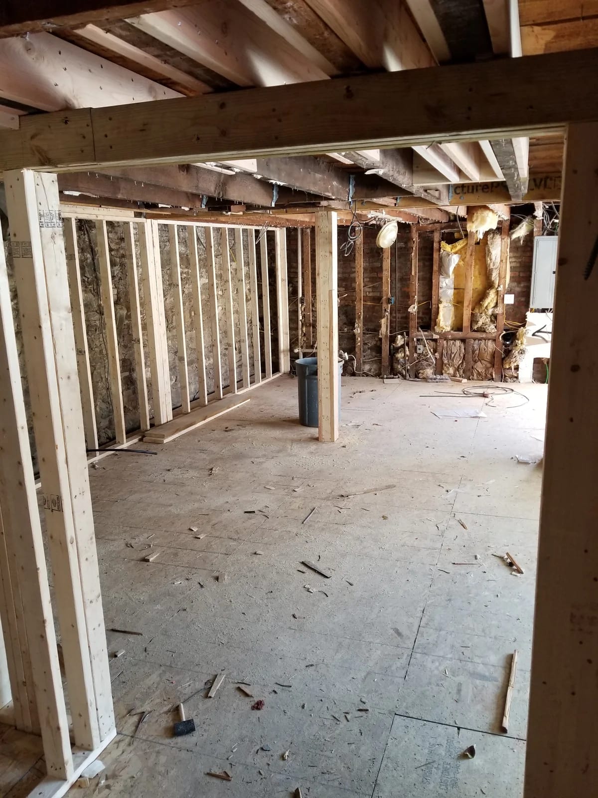 First floor during framing work with exposed ceiling joists, wall framing, and posts