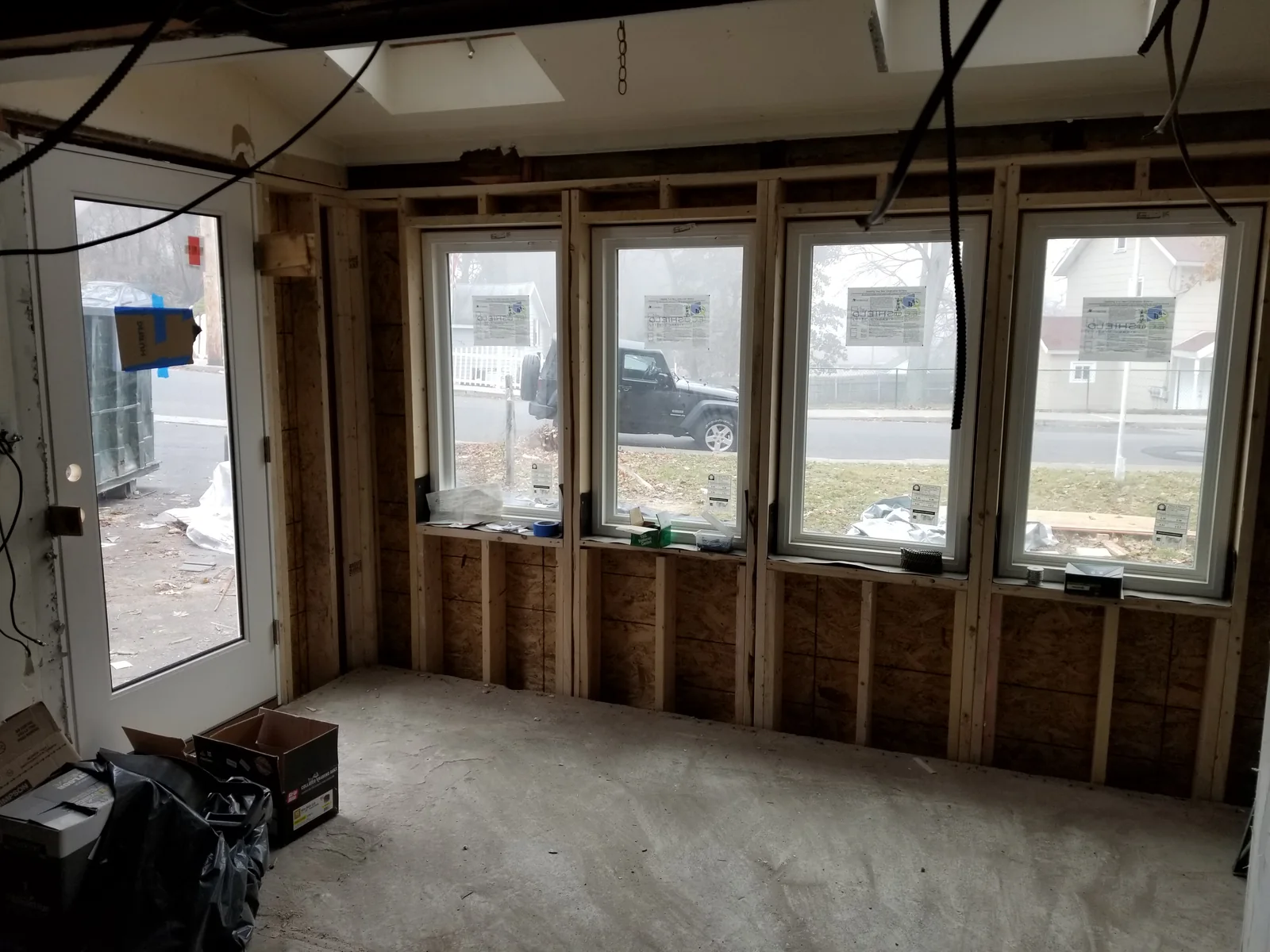 Opened wall framing beneath front windows with an exposed horizontal member above